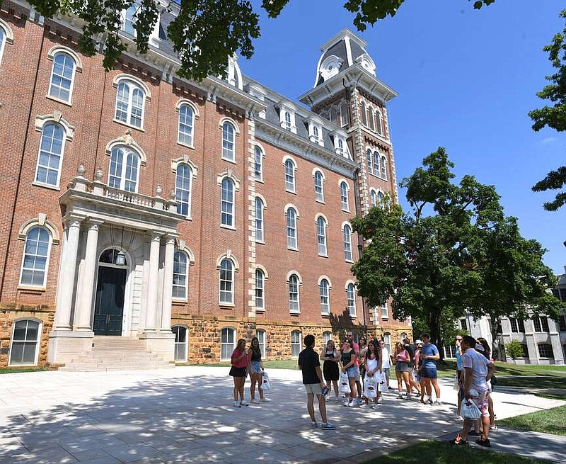 Tour group outside historic university building on sunny day