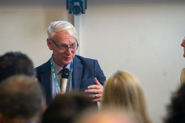 Senior man speaking at conference with microphone