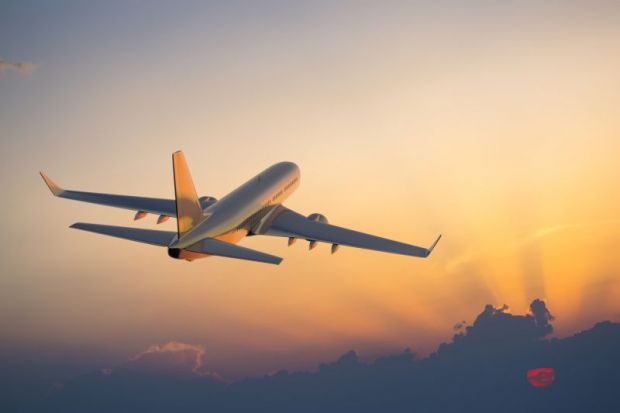 Airplane flying at sunset with golden sky