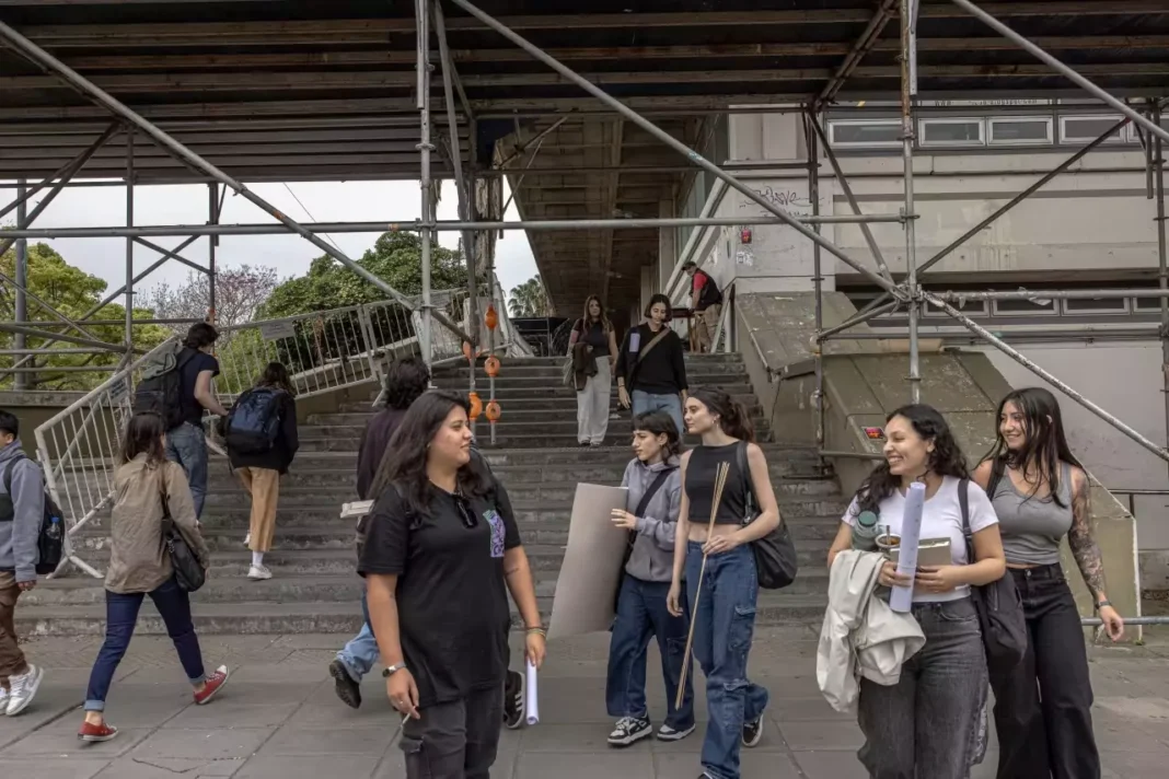 Students walking down university outdoor stairs, chatting.